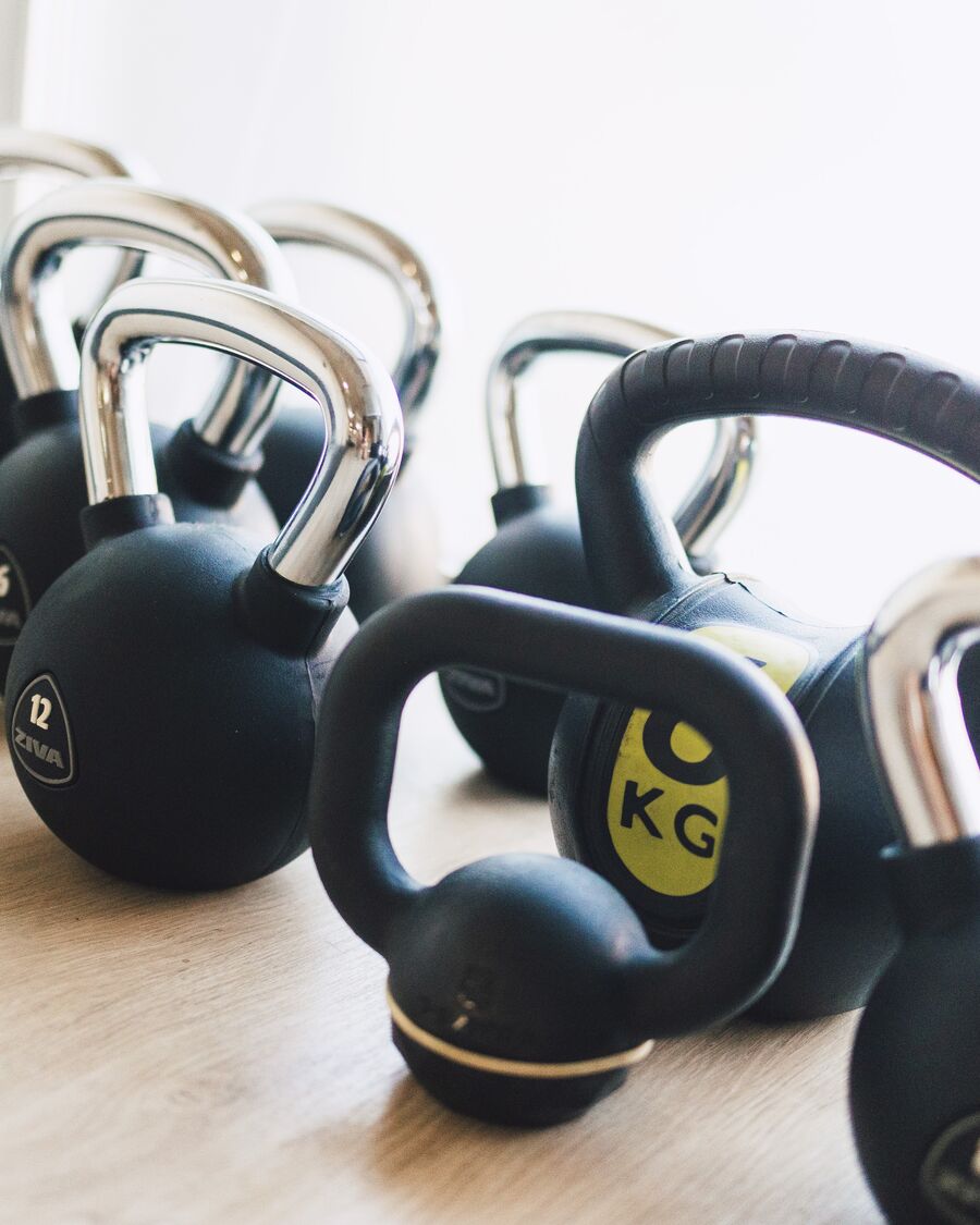Una fila de kettlebells sobre el suelo de madera.
