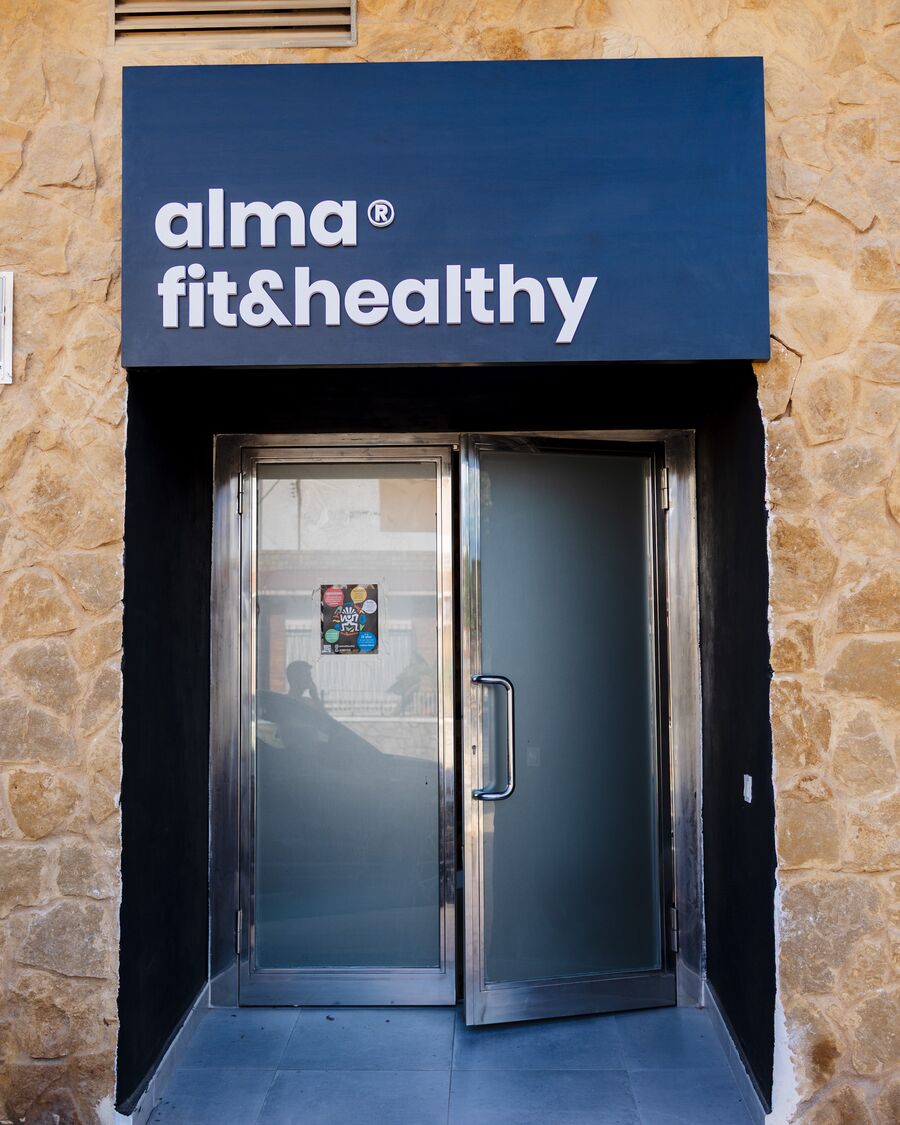 La entrada, con el rótulo azul de alma fit&healthy sobre la puerta de cristal.